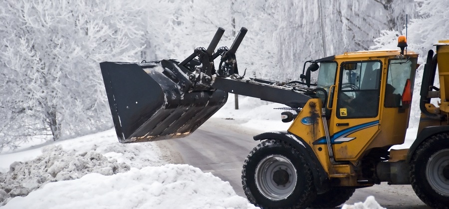 Buldozer Handling Snow - HMA Contracting Featured Image for The Threat Winter Weather Holds for Your Asphalt Pavement